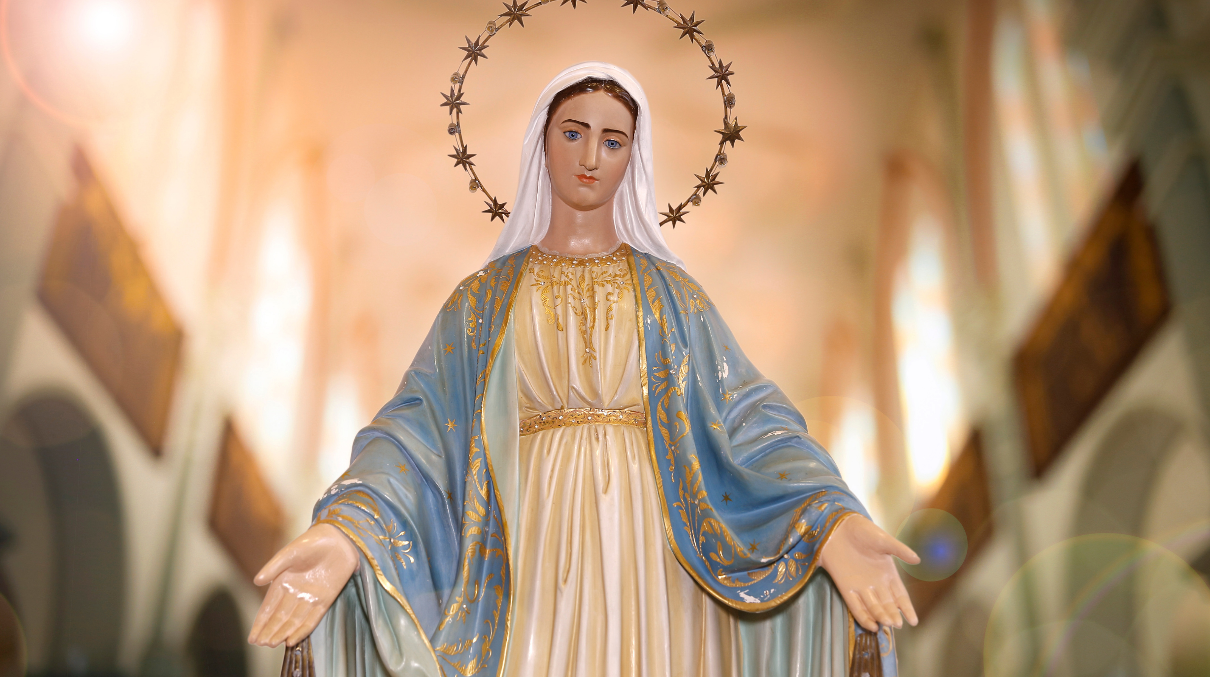Statue of the Blessed Virgin Mary with open arms in a church