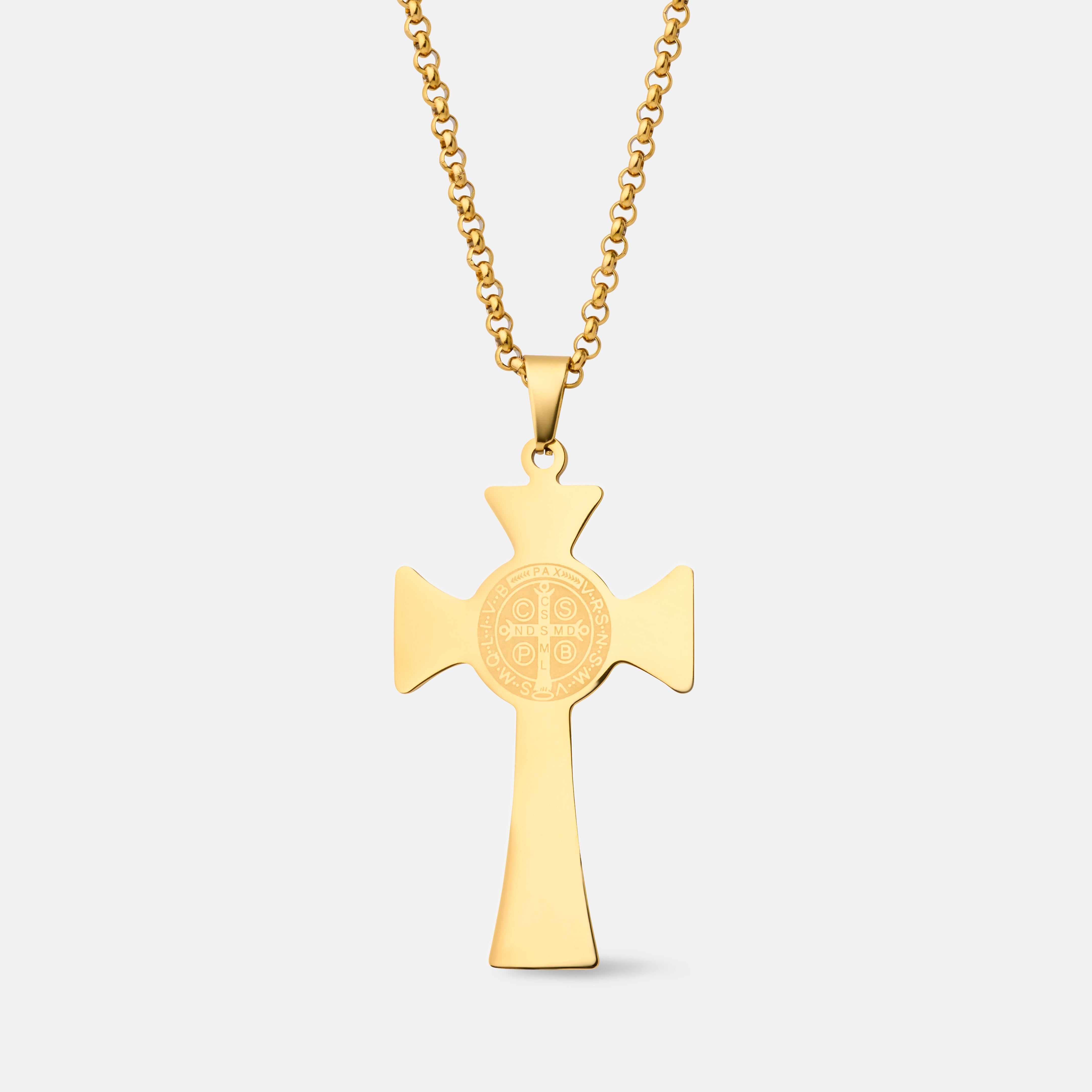 A gold cross pendant necklace with a detailed circular monogram design in the center, suspended from a gold box chain against a light gray background.