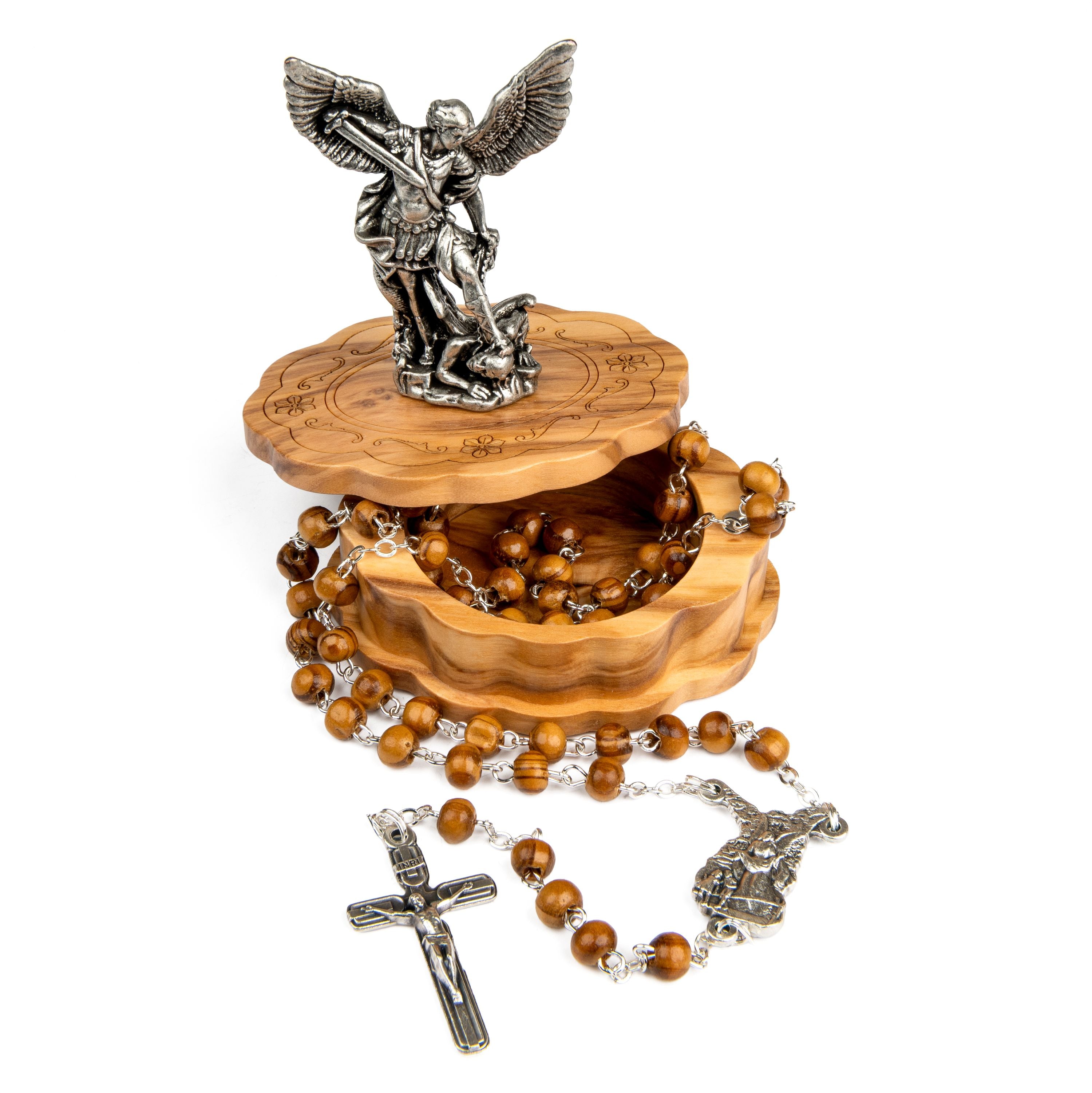A wooden rosary box with a carved lid featuring religious engravings, topped with a silver-tone angel statue. The box is open to display a brown wooden bead rosary with silver-tone metal links, a crucifix, and a centerpiece, all arranged on a plain white background.
